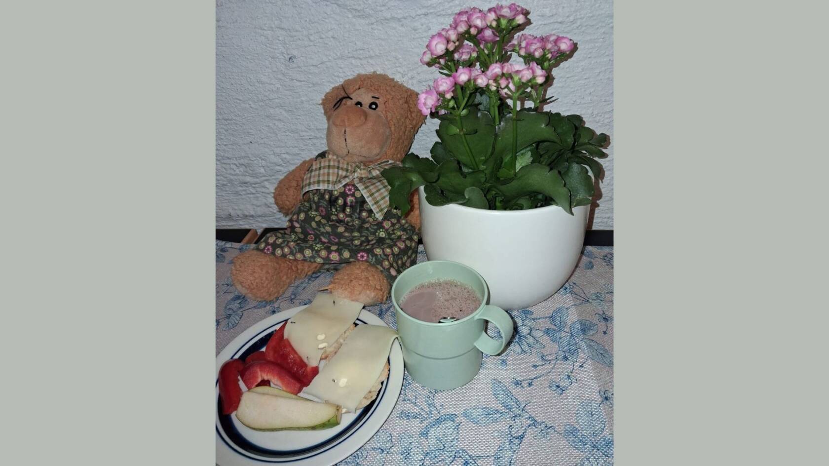Nalle, kukka, kaakaomuki ja leipälautanen.