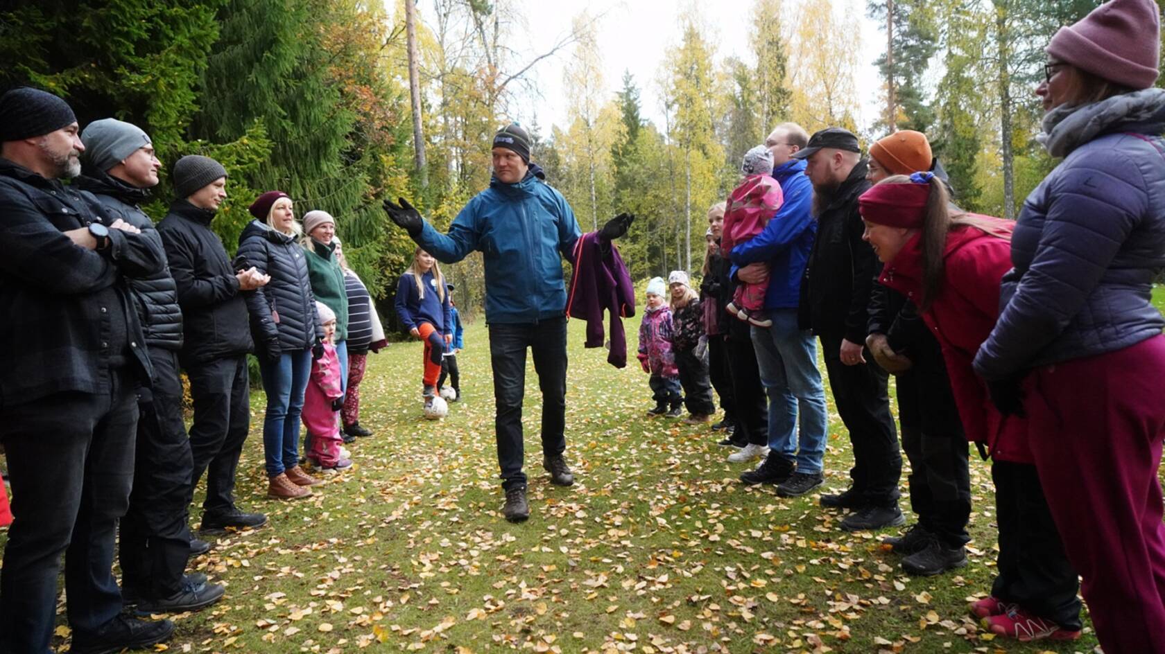 Ihmisiä ulkona kahdessa rivissä vastakkain. Jokin peli on alkamassa.